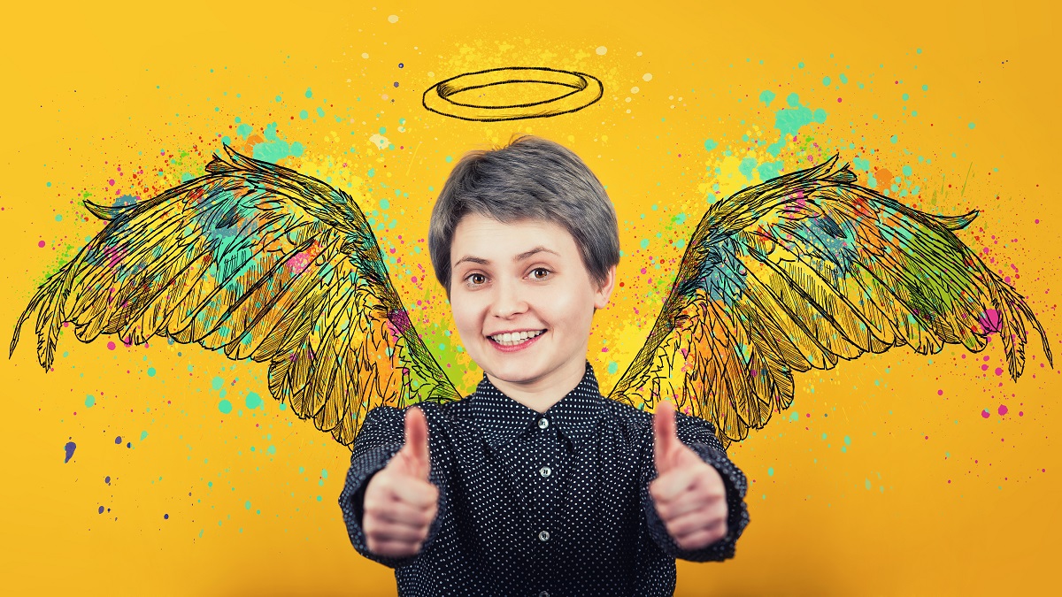 Person smiling, with two thumbs up, standing in front of a wall with colorful wings and halo. Our autistic community is powered through support from people like you. Partner with us now!