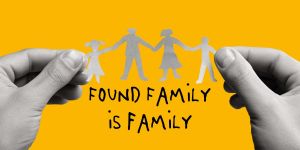 found family is family text with a pair of hands holding a paper cut out of a family
